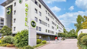 A B&B hotel with a modern design, featuring a prominent 'HOTEL' sign on the facade, multiple windows, and a gated entrance. - B&B Hotel Stuttgart-Vaihingen (Stuttgart)