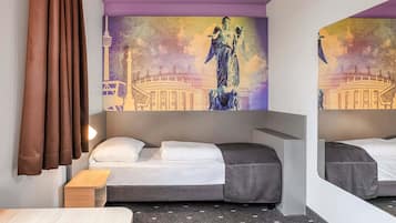Habitación de hotel con una cama, una mesita de madera, un espejo y una pared con un mural.