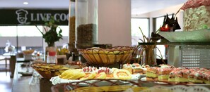 A buffet with various food items, including pastries and sandwiches, arranged on a table. - Bumiminang Hotel Padang (Padang)