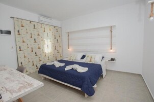 Un dormitorio con cama, una mesa y una cortina con estampado de faro.