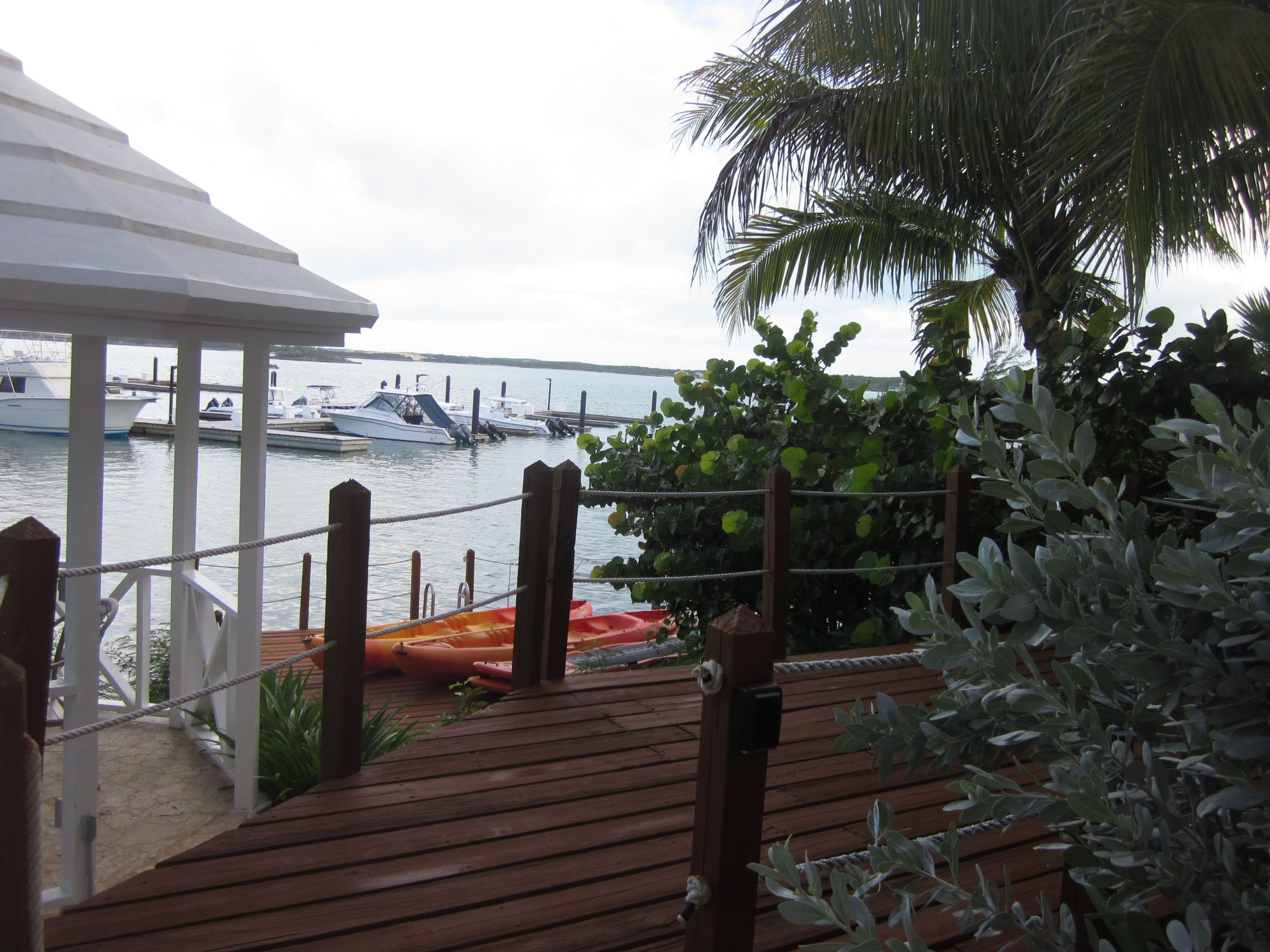 A wooden deck with a view of boats docked at a marina.