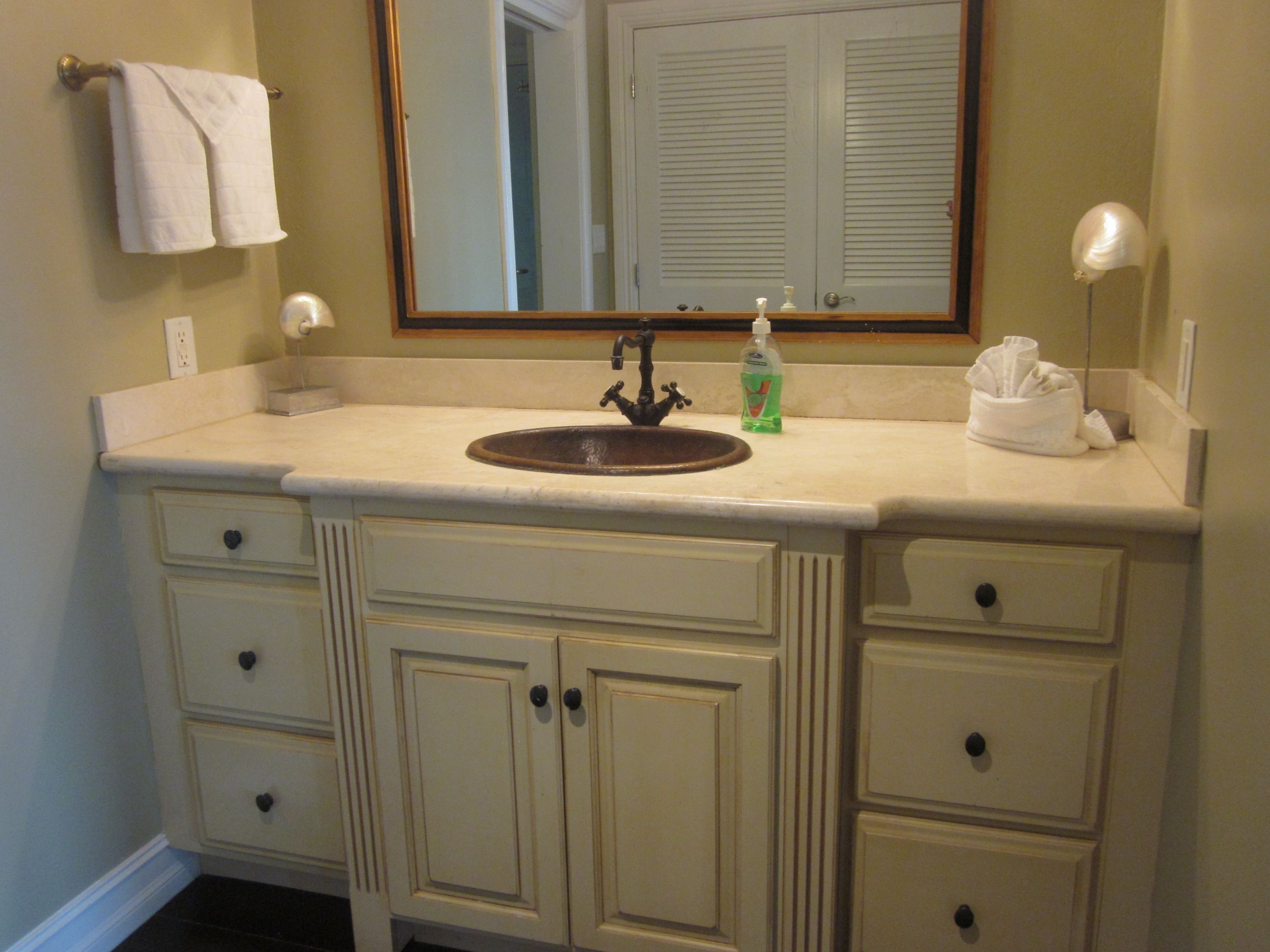A bathroom with a sink, mirror, and two drawers.