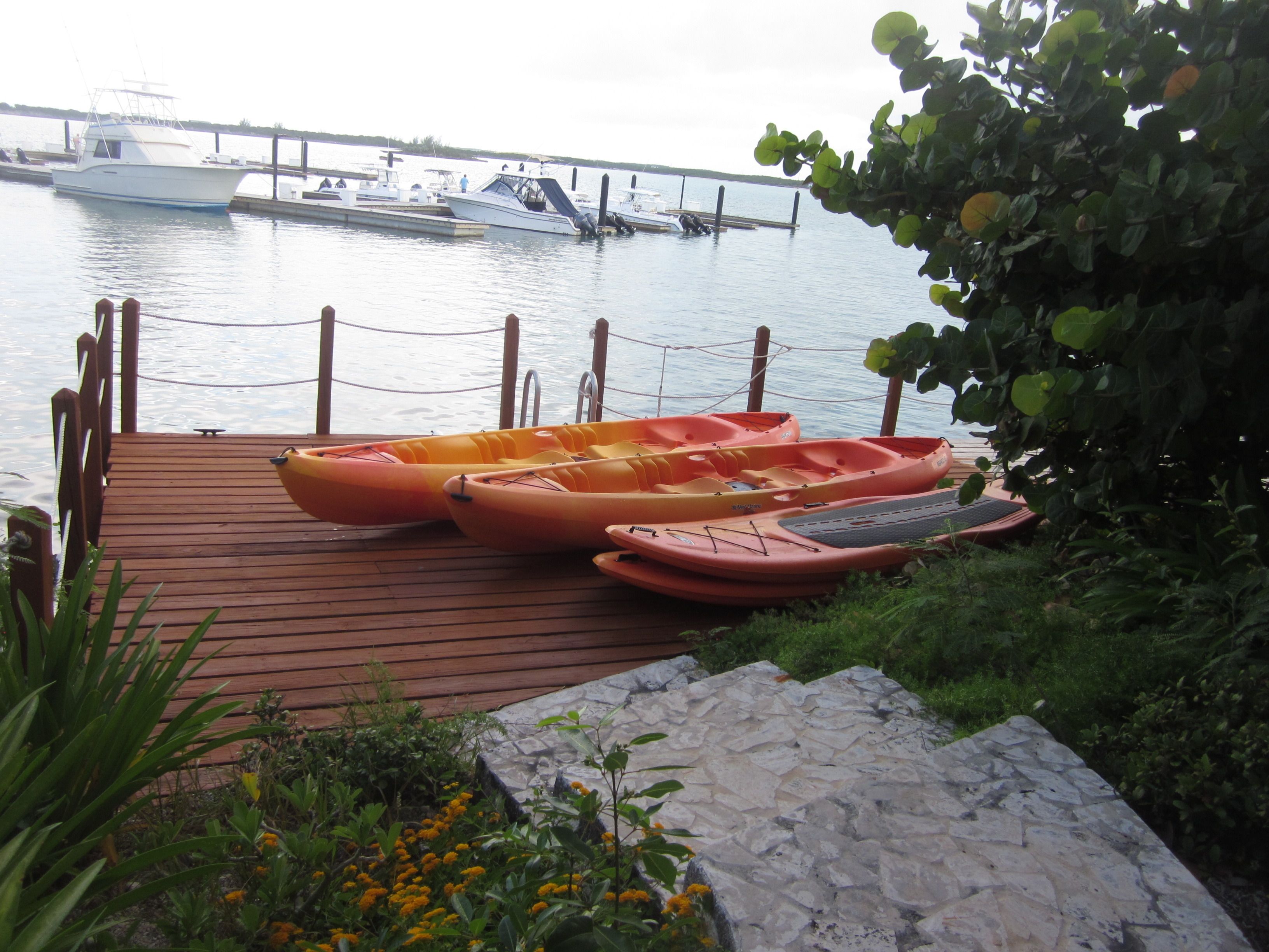 A wooden dock with kayaks and a stone pathway.