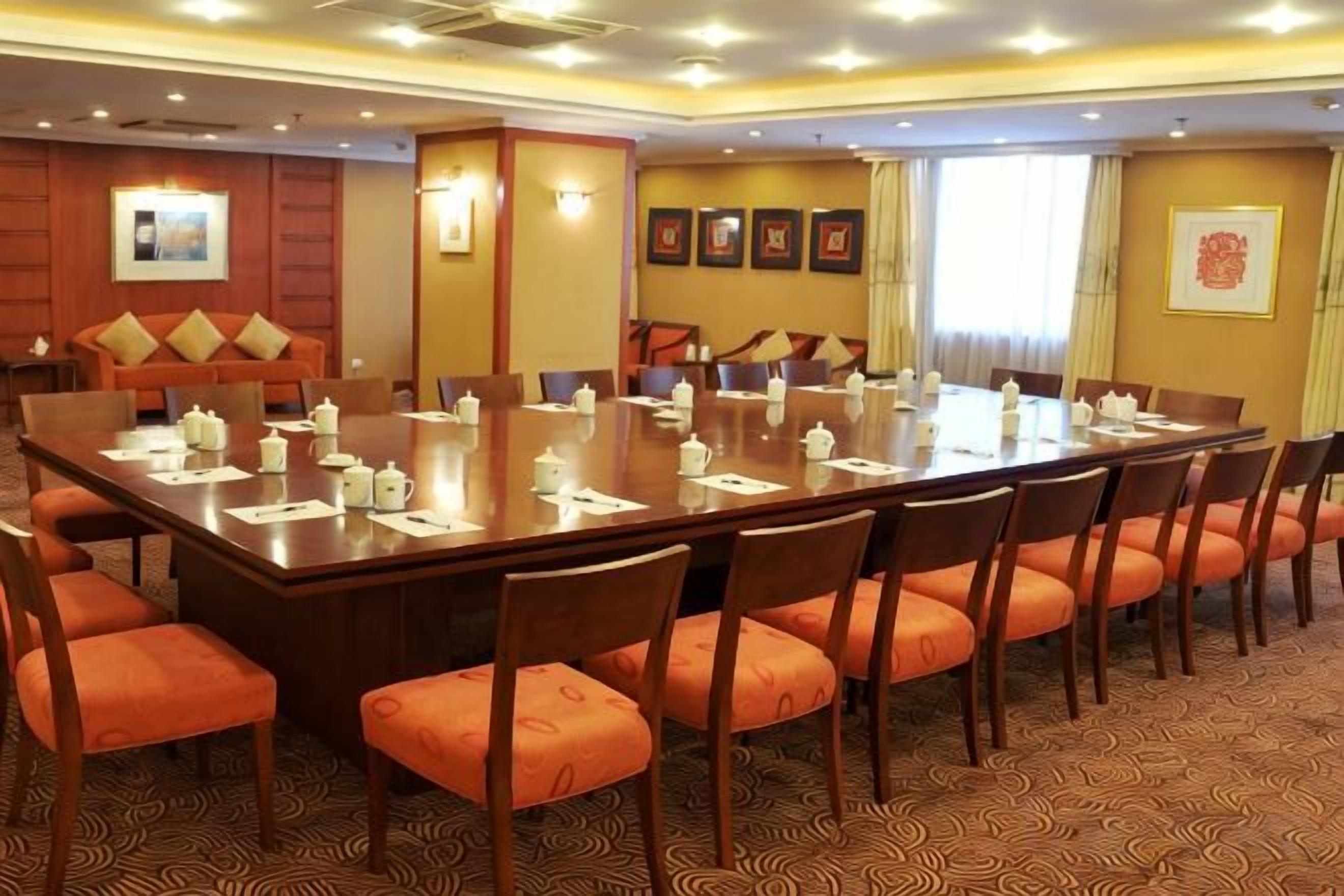 A conference room with a large table, multiple chairs, and a sofa.