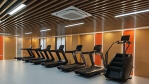 Ein Fitnessraum mit Laufbändern und Steigern.