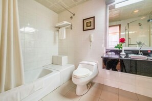 A modern bathroom with a bathtub, toilet, and vanity. - Jinmao International Hotel (HUAINAN)