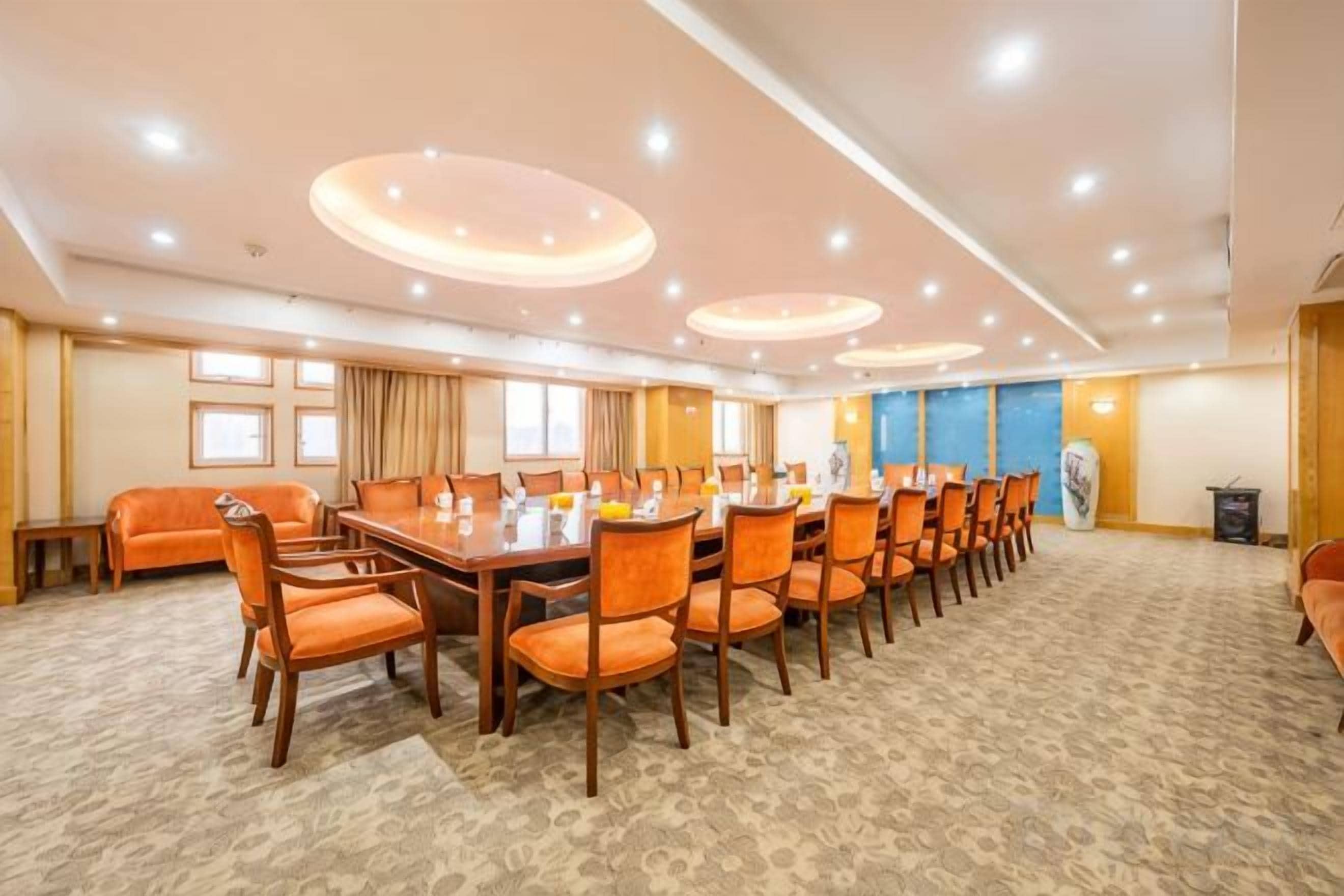 A conference room with a long table and chairs, carpeted floor, and recessed lighting.