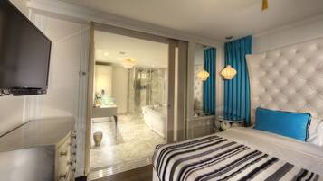 A hotel room with a bed, a TV, a bathroom with a bathtub, and a shower.