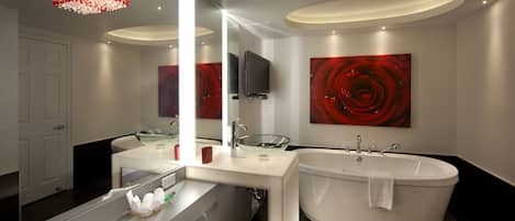 A modern bathroom with a glass bowl sink, a freestanding bathtub, and a large mirror.