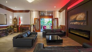 A spacious lobby with leather sofas, a grand clock, and a large painting.