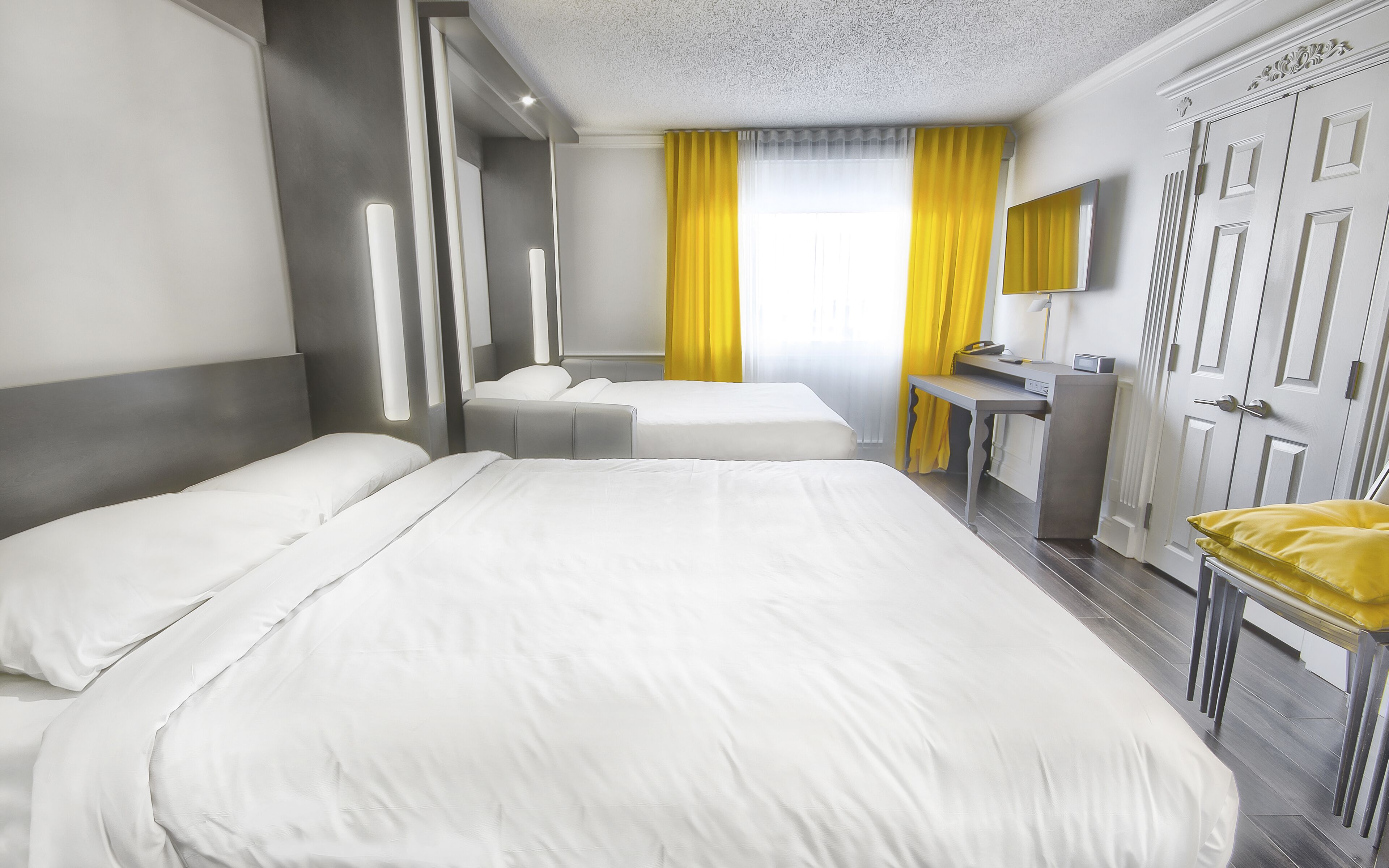 Ein Hotelzimmer mit einem großen Bett, einem Schreibtisch und einem Kleiderschrank.