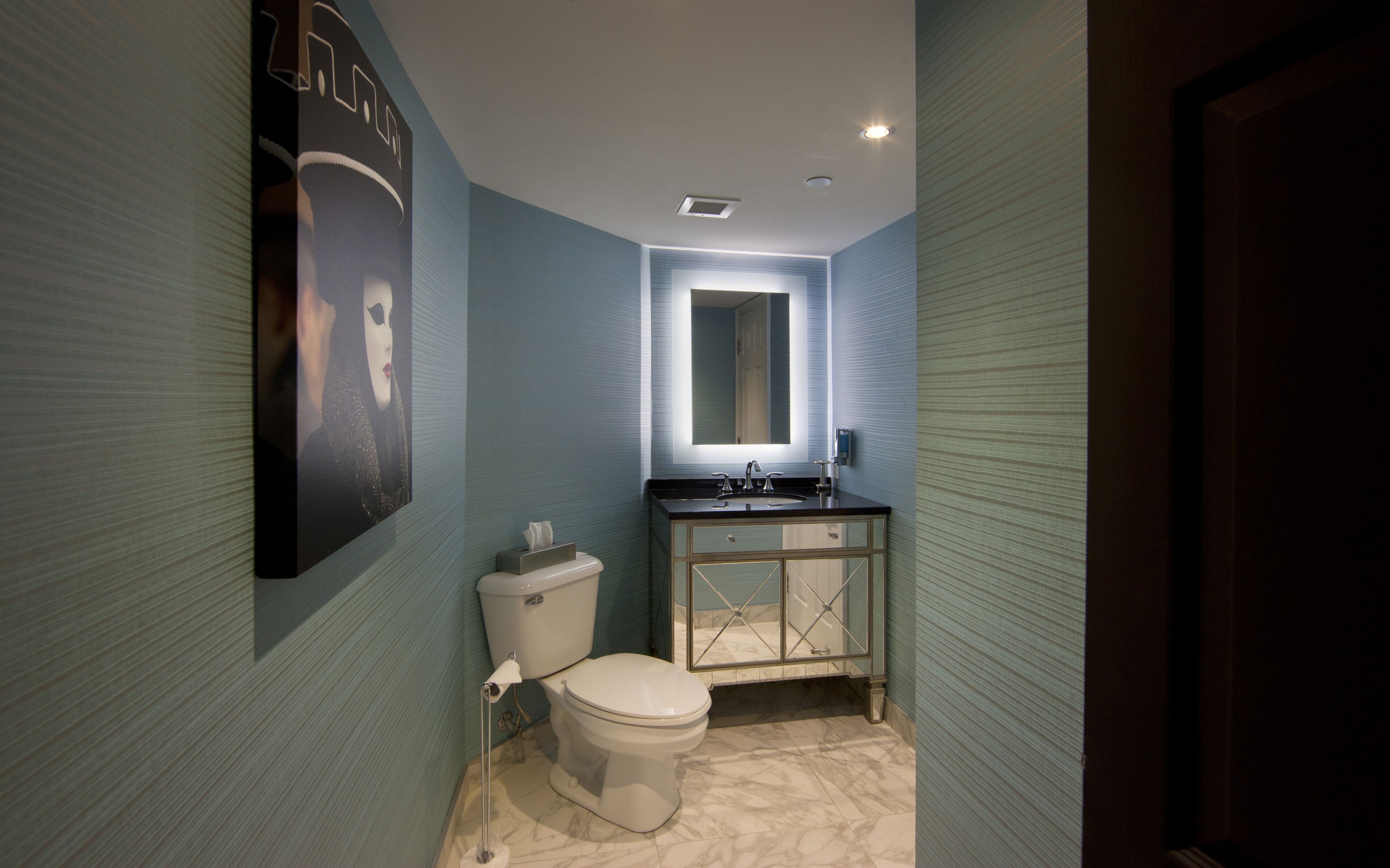 A compact bathroom with a toilet, sink, and mirror.