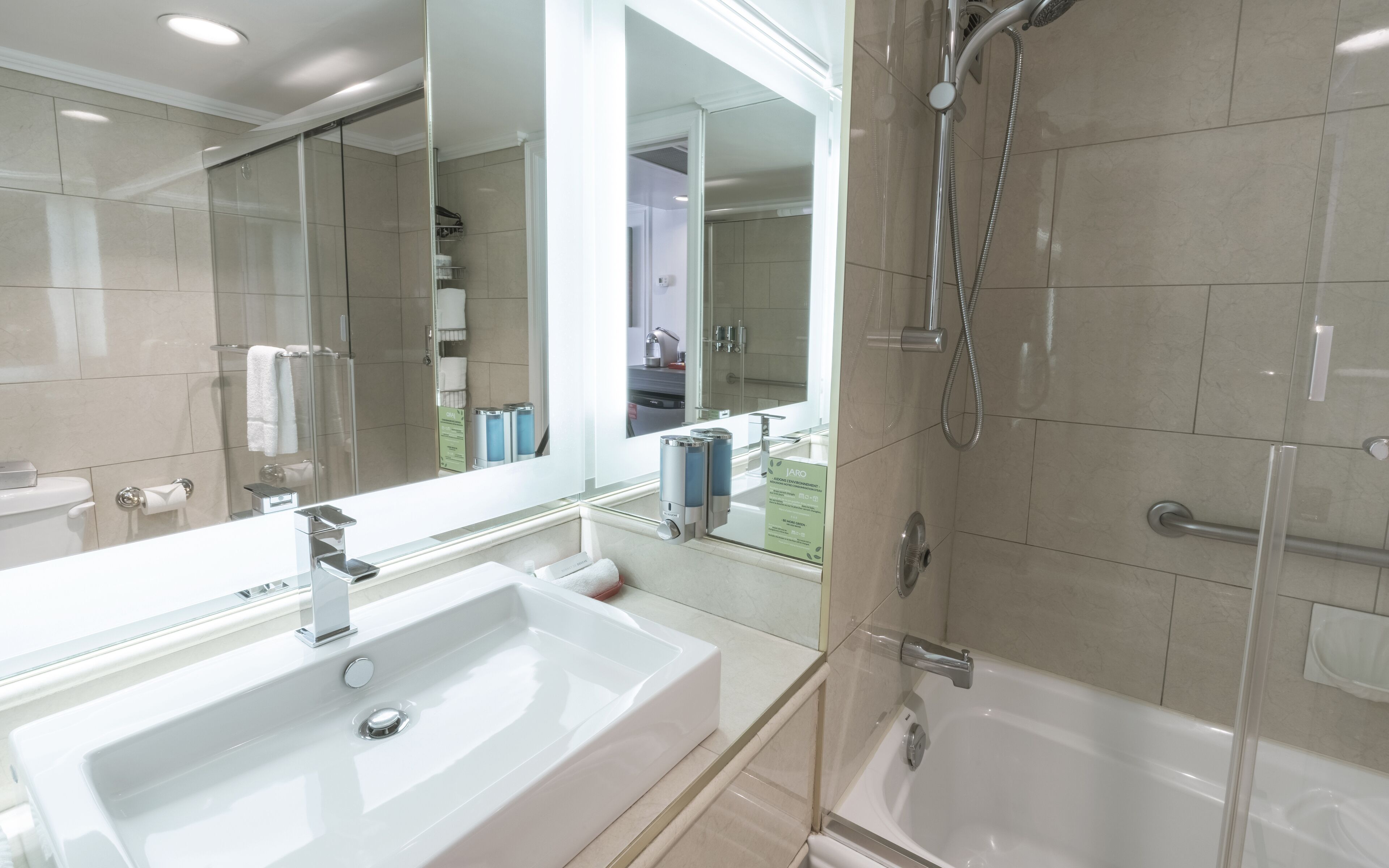 Un baño moderno con un lavamanos grande, una cabina de ducha de vidrio y un espejo.