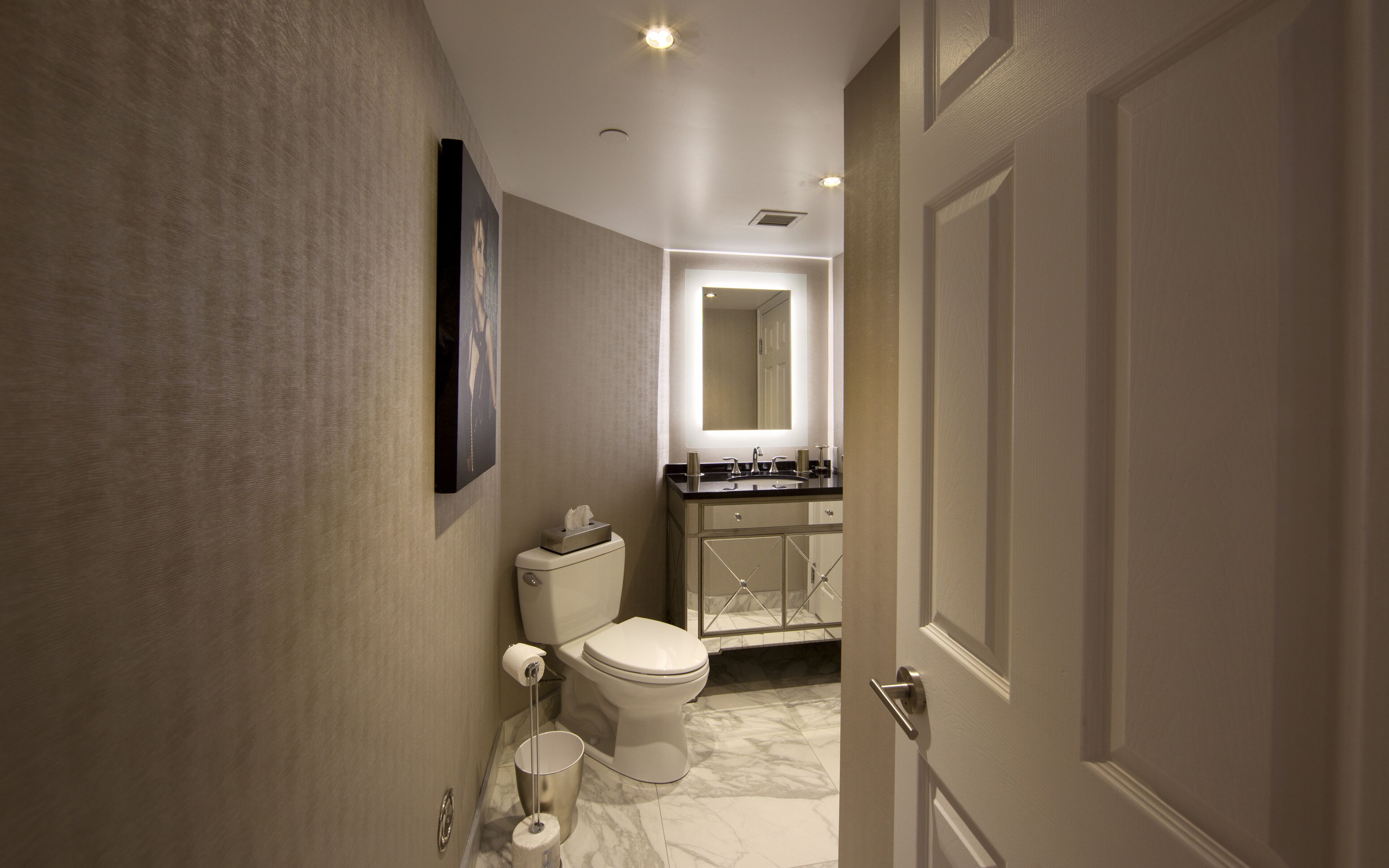 A modern bathroom with a toilet, sink, and mirror.