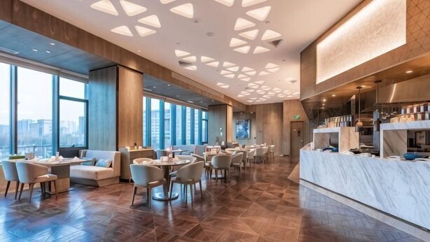 Un'ampia hall dell'hotel dal design moderno, con una zona salotto spaziosa, una reception e grandi finestre con vista sulla città.