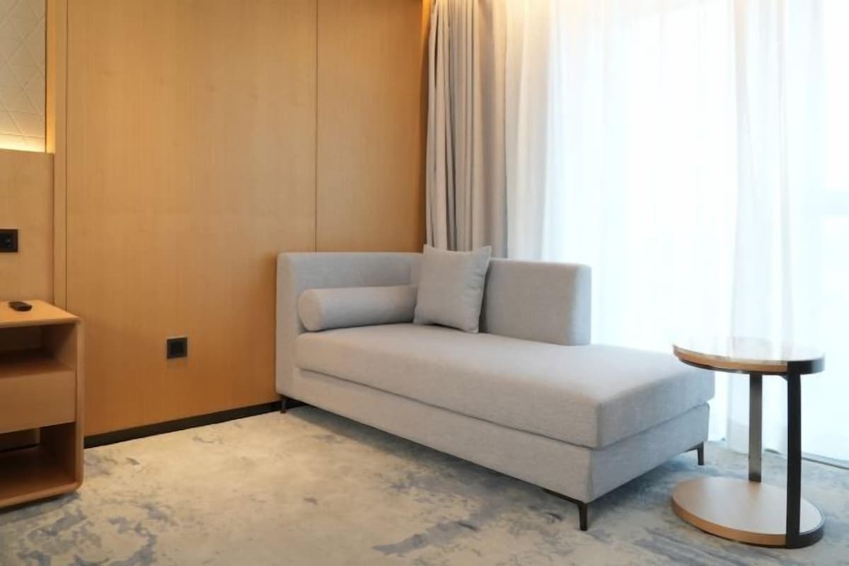 Une pièce moderne avec un canapé, une petite table ronde et un meuble en bois.