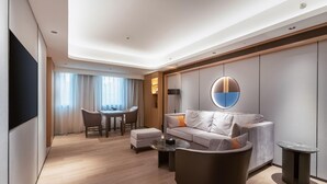 Un salon moderne avec un canapé, une table basse et un téléviseur fixé au mur.