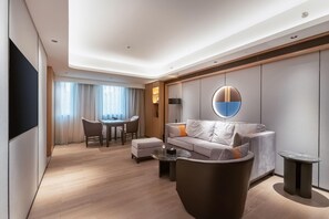 Un salon moderne avec un canapé, une table basse et un téléviseur fixé au mur.