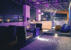 A rooftop bar with seating and a view of the cityscape. - Howard Plaza The Fern, Agra (Agra)