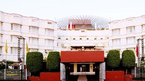 A multi-story hotel with a central atrium, a glass dome structure, and a red entrance. - Howard Plaza The Fern, Agra (Agra)