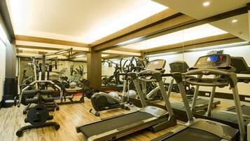 Un gimnasio con cintas de correr, elípticas y máquinas de pesas.