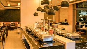 A buffet area with food service counters, hanging pendant lights, and a marble countertop. - Howard Plaza The Fern, Agra (Agra)