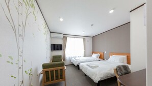 A hotel room with two beds, a desk, a chair, a TV, and a window with curtains. - Pension Lavender (Furano)