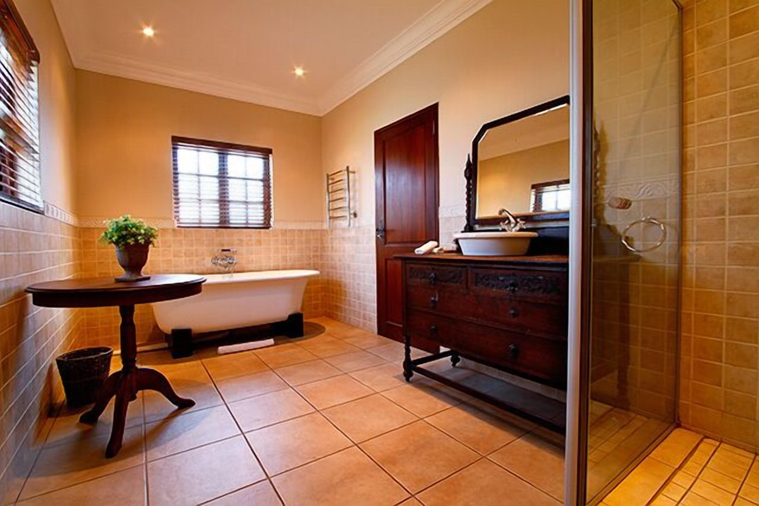 A bathroom with a bathtub, vanity, and a glass shower enclosure.