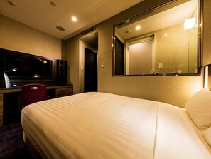 A hotel room with a large bed, a desk with a computer, a TV, and a mirror. - Jr-east Hotel Mets Urawa (Saitama)