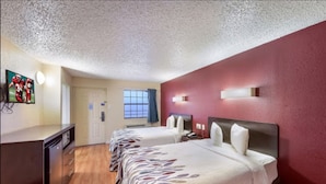 A hotel room with two beds, a TV, a desk, and a window with curtains. - Red Roof Inn Plano (Plano)