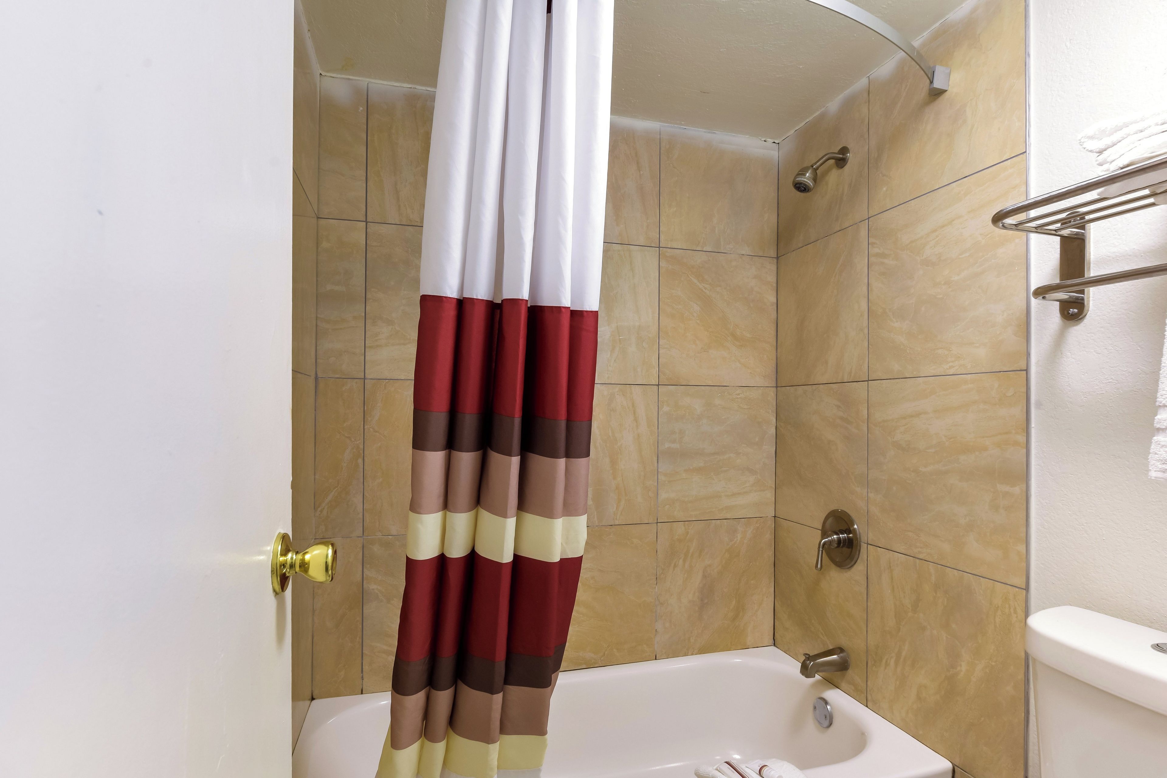 Un bagno con una vasca, un water e una tenda da doccia.