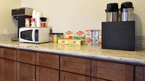 A kitchen with a microwave, coffee maker, Lipton tea boxes, and two thermos flasks. - Red Roof Inn Plano (Plano)