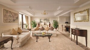 A spacious living room with a sofa set, a glass coffee table, and a fireplace. - Shangri-la Hotel (Shenzhen)