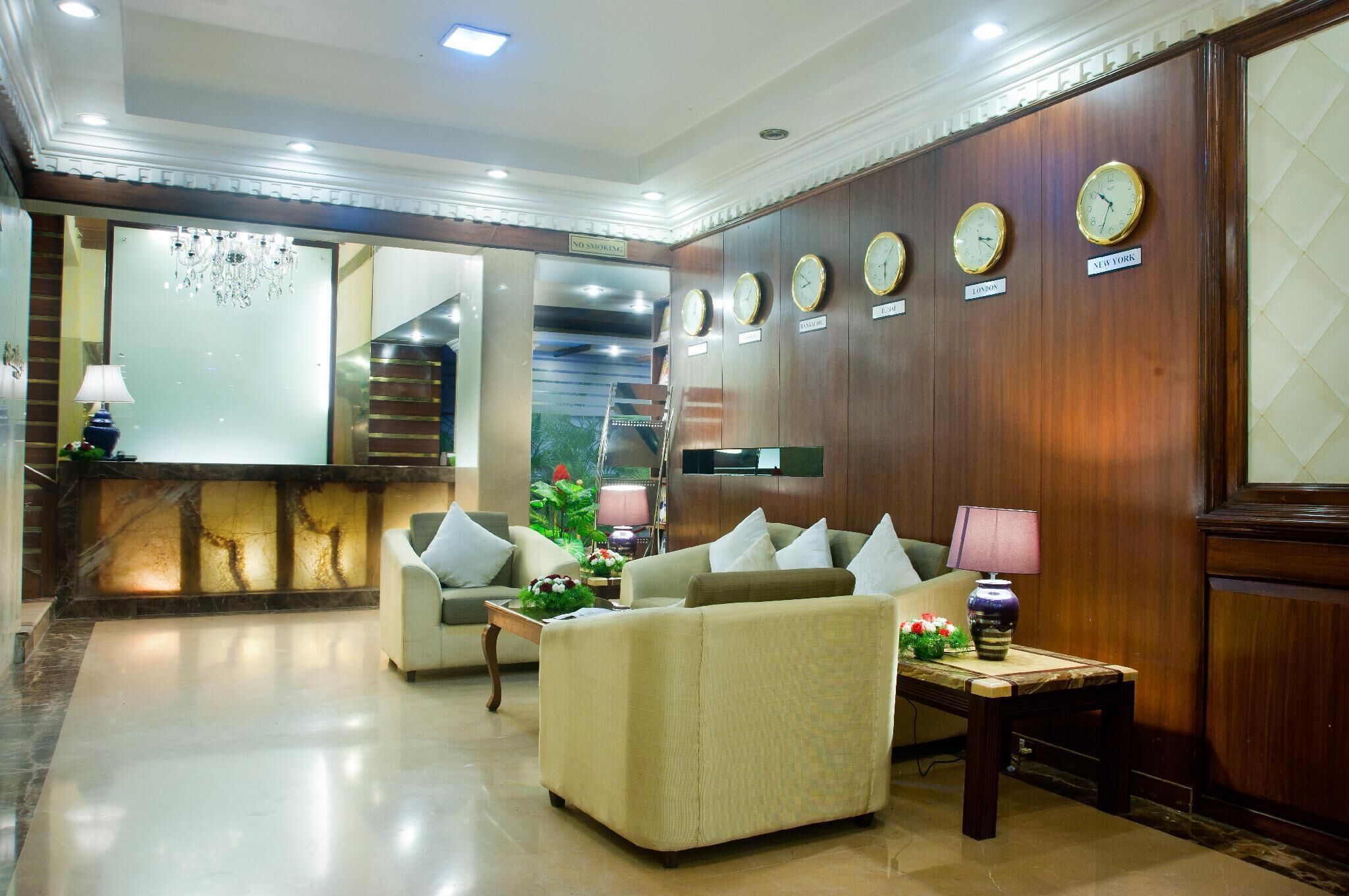 A lobby with a reception desk, two sofas, a coffee table, and clocks labeled with city names.