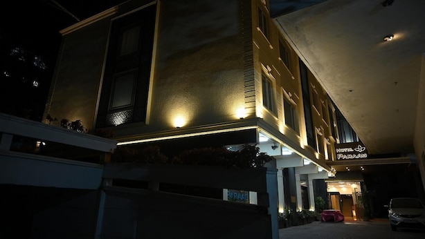 Un hotel con fachada moderna, ventanas iluminadas y un letrero que dice "Hotel Paraag".
