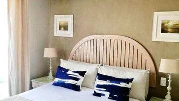 A hotel room with a bed, two bedside tables, and two lamps.