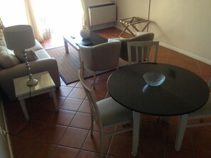 A living room with a sofa, chairs, a small table, and a round table. - Leisure Bay (Cape Town)