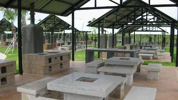 An outdoor pavilion with stone benches and a central fire feature.