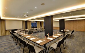 A conference room with a long table, chairs, water bottles, and a projector screen. - Capetonian Hotel (Cape Town)