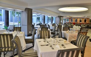 A restaurant with multiple tables and chairs, large windows, and a modern interior design. - Capetonian Hotel (Cape Town)