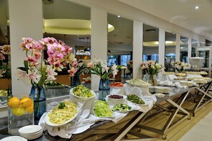 Un bufé con diversos platos y una decoración floral.