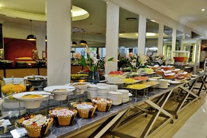 A buffet with various food items and a floral centerpiece. - Capetonian Hotel (Cape Town)