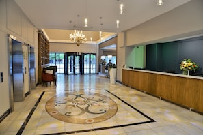 A spacious lobby with a reception desk, a chandelier, and a patterned floor. - Capetonian Hotel (Cape Town)
