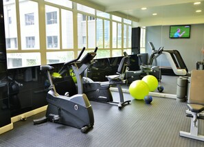 A gym with treadmills, exercise balls, and a TV screen displaying a sports event. - Capetonian Hotel (Cape Town)