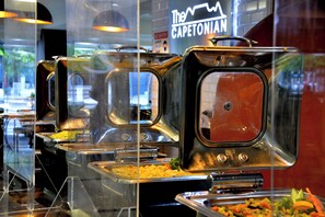 A buffet with multiple serving stations, each with a covered food container. - Capetonian Hotel (Cape Town)