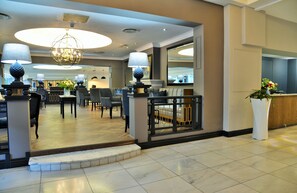 A hotel lobby with a reception desk, seating area, and a chandelier. - Capetonian Hotel (Cape Town)