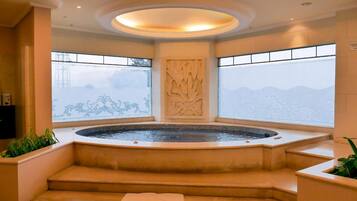 A spa area with a hot tub, steps leading to it, and decorative wall panels.