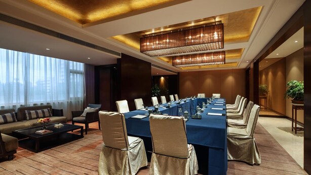 A conference room with a long table, chairs, and a chandelier. - Haitian Hotel (Kunming)