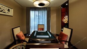 A room with a pool table, two armchairs, a chandelier, and a large window with curtains. - Haitian Hotel (Kunming)