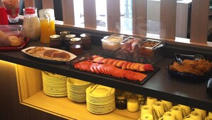 A breakfast buffet with various food items and condiments. - Metropoli Suites Ejecutivas (Puebla)
